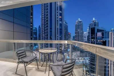 a balcony with a table and chairs and a city skyline at Downtown Dubai- Modern upgraded 1 BR Plus Study Room with Luxury Interiors and Partial Fountain Views in Dubai