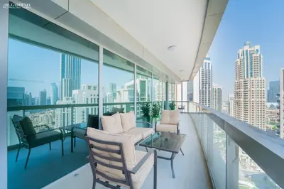 a balcony with chairs and a table and some windows at Downtown Dubai- Modern upgraded 1 BR Plus Study Room with Luxury Interiors and Partial Fountain Views in Dubai