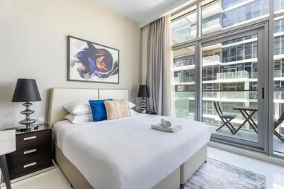 a bedroom with a large bed and a large window at GuestReady - Golf View | Park Access | DAMAC Hills in Dubai