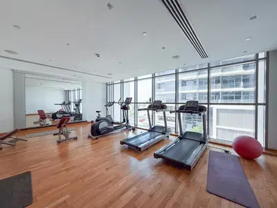 a gym with treadmills and ellipticals in a building at GuestReady - Golf View | Park Access | DAMAC Hills in Dubai
