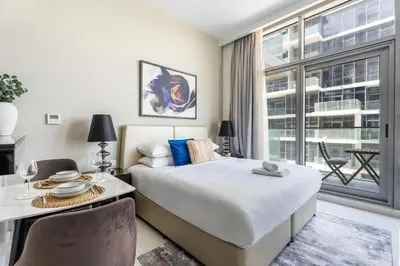 a bedroom with a bed and a desk and a window at GuestReady - Golf View | Park Access | DAMAC Hills in Dubai