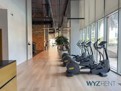 a gym with rows of treadmills and elliptical machines at Emerald Boho Escape1BR in Forte near Burj Khalifa in Dubai