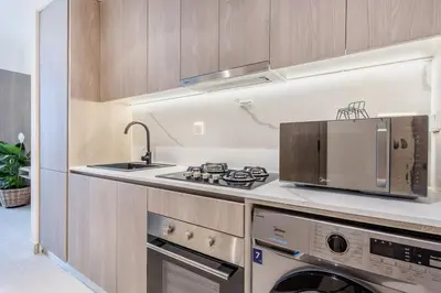 a kitchen with a sink and a stove top oven at Urban Oasis - Modern Studio Retreat with City Views in Dubai