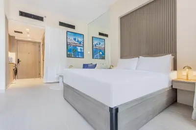a bedroom with a large white bed in a room at Urban Oasis - Modern Studio Retreat with City Views in Dubai