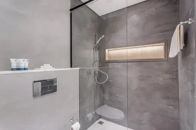 a bathroom with a shower and a toilet in it at Urban Oasis - Modern Studio Retreat with City Views in Dubai