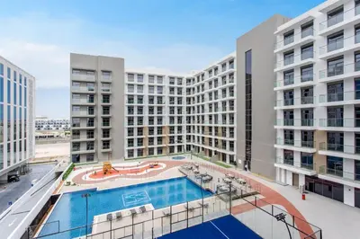an apartment building with a pool in the middle at Urban Oasis - Modern Studio Retreat with City Views in Dubai