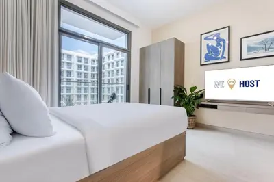 a bedroom with a white bed and a tv at Urban Oasis - Modern Studio Retreat with City Views in Dubai