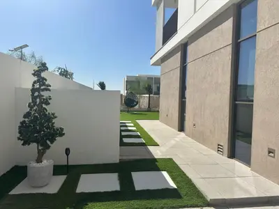 a courtyard with a tree next to a building at Luxury 4BR and Maid Room Townhouse Tilal Al Furjan in Dubai
