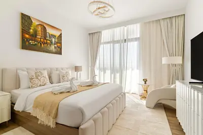 a white bedroom with a large bed and a large window at Luxury 4BR and Maid Room Townhouse Tilal Al Furjan in Dubai