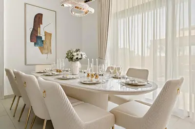 a white dining room with a white table and chairs at Luxury 4BR and Maid Room Townhouse Tilal Al Furjan in Dubai