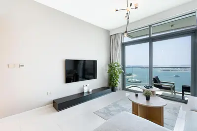 a living room with a tv and a large window at Dubai Dream Stay - 2-BR with Sea View in Beach Vista in Dubai