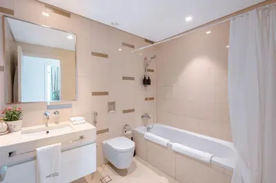 a bathroom with a tub and a toilet and a sink at Dubai Dream Stay - 2-BR with Sea View in Beach Vista in Dubai