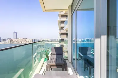 a balcony with chairs and a view of the water at Dubai Dream Stay - 2-BR with Sea View in Beach Vista in Dubai