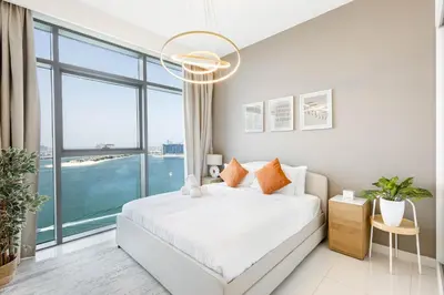 a bedroom with a bed and a large window at Dubai Dream Stay - 2-BR with Sea View in Beach Vista in Dubai