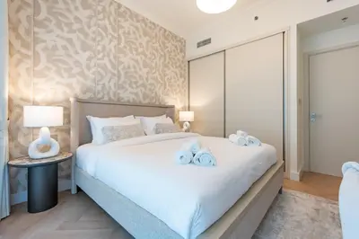 a bedroom with a large bed with towels on it at Prime 1 Bedroom with Private Beach in Beachfront in Dubai