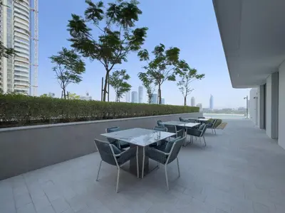 a row of tables and chairs on a balcony with trees at Prime 1 Bedroom with Private Beach in Beachfront in Dubai