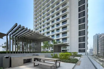 a picnic table and bench in front of a building at Prime 1 Bedroom with Private Beach in Beachfront in Dubai