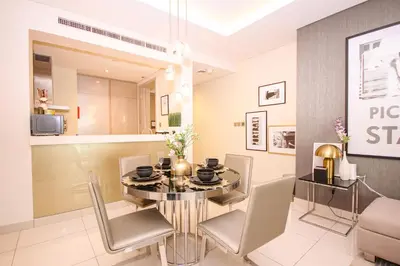 a dining room with a glass table and chairs at Stay in Style at Paramount Towers Spacious 1BR High Floor Luxury Furniture Branded Amenties in Dubai