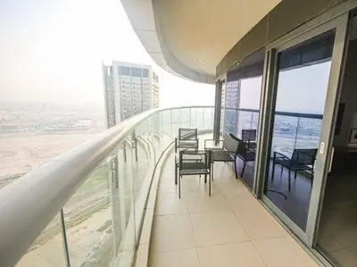 a balcony with chairs and tables in a building at Stay in Style at Paramount Towers Spacious 1BR High Floor Luxury Furniture Branded Amenties in Dubai