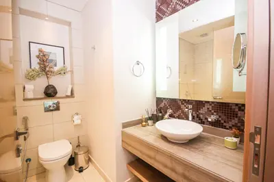 a bathroom with a sink and a toilet and a mirror at Stay in Style at Paramount Towers Spacious 1BR High Floor Luxury Furniture Branded Amenties in Dubai
