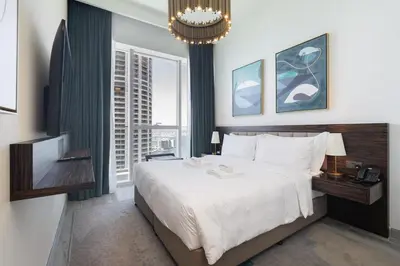 a bedroom with a large bed and a chandelier at Luxury 2BHK Sea & Palm Views 20th Floor Tram line in Dubai
