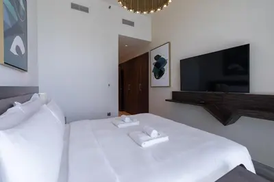 a bedroom with a white bed with two towels on it at Luxury 2BHK Sea & Palm Views 20th Floor Tram line in Dubai
