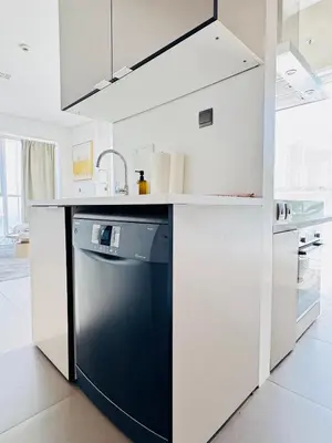 a white kitchen with a dishwasher and a sink at One bedroom Apartment in Dubai Marina next to the Marina Mall in Dubai