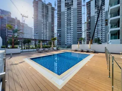 a swimming pool on the roof of a building with tall buildings at New Charming 2BR with Gym & Pool in Azizi Riviera in Dubai