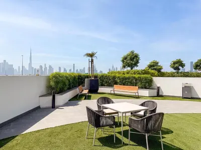 a table and chairs on a roof with a view of the city at GuestReady - Furnished Studio | Burj & Canal Views in Dubai
