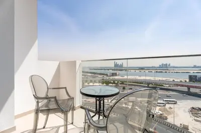 a balcony with a table and chairs and a view of the ocean at GuestReady - Furnished Studio | Burj & Canal Views in Dubai