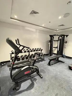 a gym with several tread machines in a room at Spacious 1BR JVC Circle Mall at Your Doorstep in Dubai