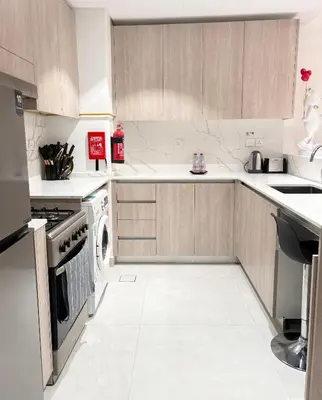 a kitchen with white counters and white appliances at Spacious 1BR JVC Circle Mall at Your Doorstep in Dubai