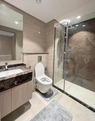 a bathroom with a shower and a toilet and a sink at Spacious 1BR JVC Circle Mall at Your Doorstep in Dubai