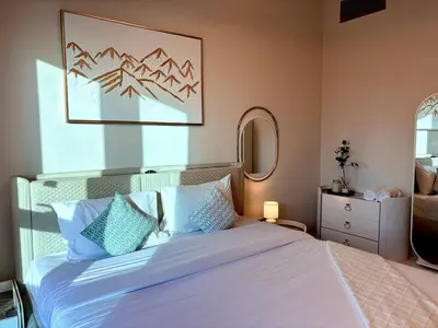 a bedroom with a large white bed with blue pillows at The Greendoor - Lake and Sea View, JLT in Dubai