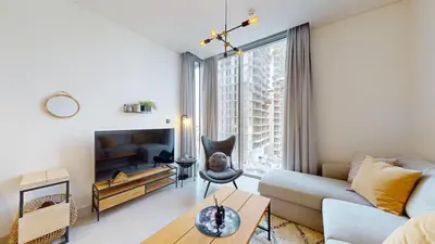 a living room with a couch and a table at Locations l Elegant One Bedroom l City Views and Free Pool, Gym Access in Dubai