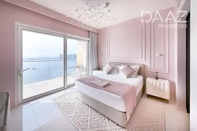 a bedroom with a large bed and a large window at Branded 2BR in Nakhlat Jumeira - Palm View in Dubai