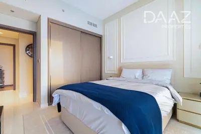 a bedroom with a large bed with a blue blanket at Branded 2BR in Nakhlat Jumeira - Palm View in Dubai