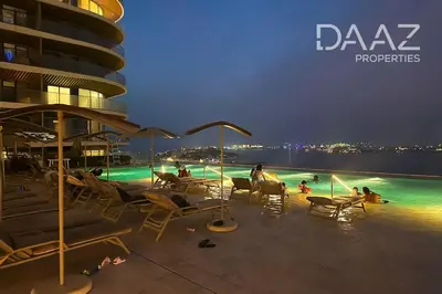 a group of people sitting in chairs on a beach at night at Branded 2BR in Nakhlat Jumeira - Palm View in Dubai