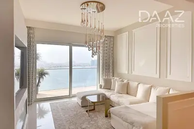 a living room with a couch and a chandelier at Branded 2BR in Nakhlat Jumeira - Palm View in Dubai