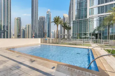 a swimming pool in the middle of a city with tall buildings at Vogue Downtown Forte near Dubai Mall and Burj Khalifa, Three-Bedroom Plus Kids room with Balcony and Fountain view, full access to all amenities in Dubai
