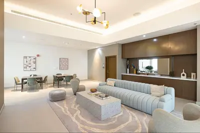a living room with a blue couch and a table at Vogue Downtown Forte near Dubai Mall and Burj Khalifa, Three-Bedroom Plus Kids room with Balcony and Fountain view, full access to all amenities in Dubai