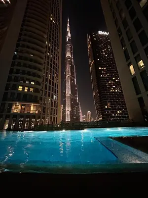 a swimming pool with a view of the shard at night at Private room in 3BR Ultra-Luxury-High-Rise Apartment next to BURJ KHALIFA, DUBAI MALL in Dubai