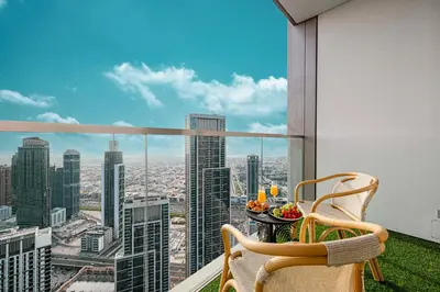 a balcony with a table and chairs and a view of a city at Luxury Grande Suites by Hostiva - Full City View in Dubai