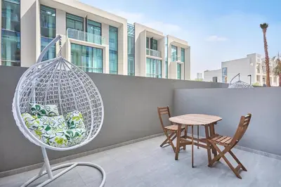 a patio with two chairs and a table and a swing at Luxury-Comfort & Elegance Studio in Dubai