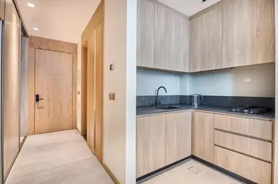 a kitchen with wooden cabinets and a door at Luxury-Comfort & Elegance Studio in Dubai