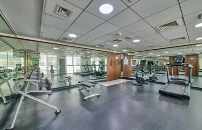 a gym with several treadmills and exercise bikes at Grand Stay Holiday Homes Rental 2 in Dubai