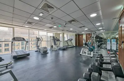 a gym with treadmills and elliptical machines at Grand Stay Holiday Homes Rental 2 in Dubai
