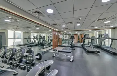 a gym with several treadmills and cardio machines at Grand Stay Holiday Homes Rental 2 in Dubai
