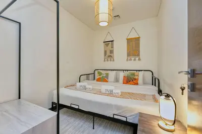a bedroom with a bed and a glass door at PVH Stylish Boho 1BR with Study - The Crest in Dubai