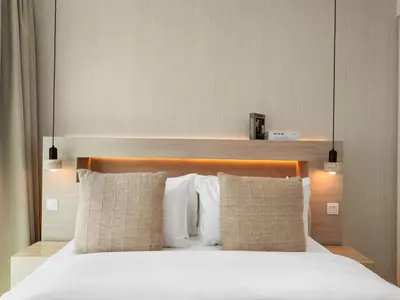 a bedroom with a bed with white sheets and pillows at Downtown 4BDR Apartment Opposite Dubai Mall, Burj Khalifa Views in Dubai